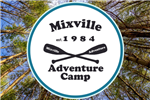 picture looking skyward with tall trees and mixville adventure camp logo in middle