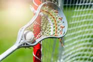 photo of lacrosse stick with ball and goal